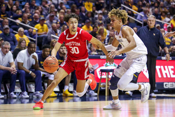 Boston University Terriers guard Javante McCoy (30) drives past West Virginia Mountaineers forward Emmitt Matthews Jr. (11) during the first half at WVU Coliseum.